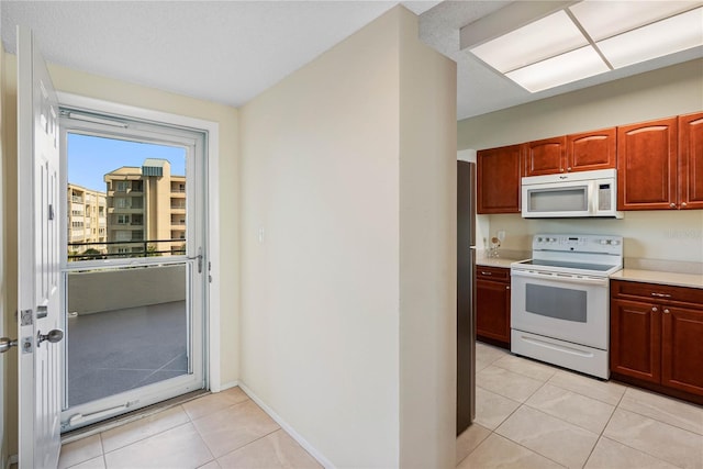 7932 Sailboat Key Blvd S Unit 406, South Pasadena, FL 33707 - kitchen with white appliances, light countertops, and light tile patterned flooring