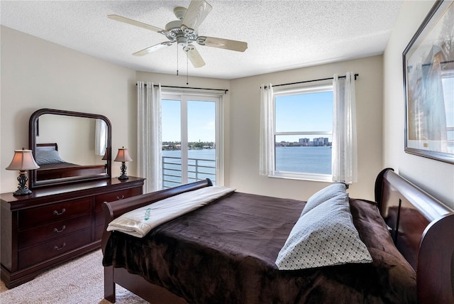 7932 Sailboat Key Blvd S Unit 406, South Pasadena, FL 33707 - bedroom with access to outside, multiple windows, light colored carpet, a textured ceiling, and a ceiling fan