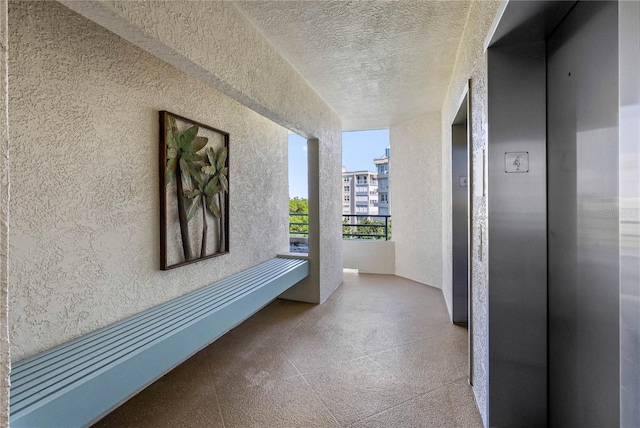 7932 Sailboat Key Blvd S Unit 406, South Pasadena, FL 33707 - hall featuring a textured wall, elevator, and a textured ceiling