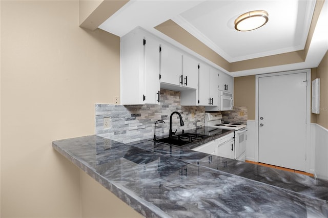1881 Lichen Ln Unit B, Clearwater, FL 33760 - kitchen with white appliances, a sink, backsplash, white cabinets, and a peninsula