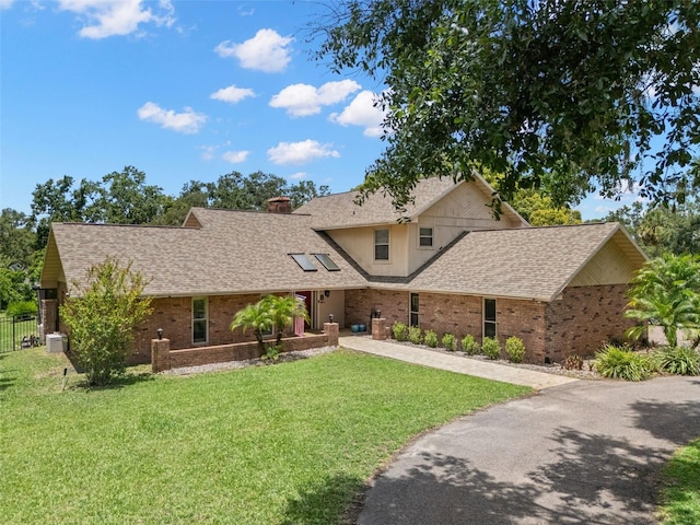 2306 S Valrico Rd, Valrico, FL 33596 - view of front of house featuring brick siding, asphalt driveway, a chimney, and a shingled roof