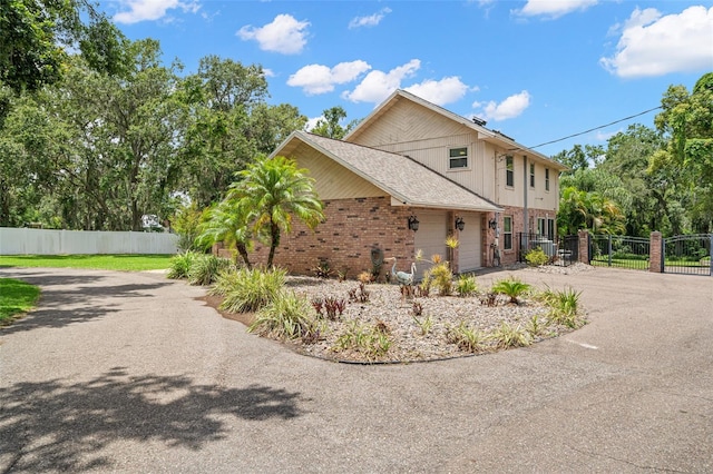 2306 S Valrico Rd, Valrico, FL 33596 - view of side of property featuring asphalt driveway, brick siding, and a gate