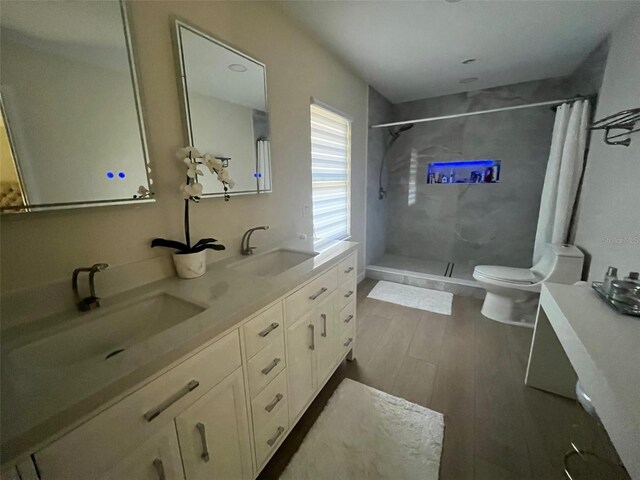 2306 S Valrico Rd, Valrico, FL 33596 - full bath with a stall shower, wood finished floors, and double vanity