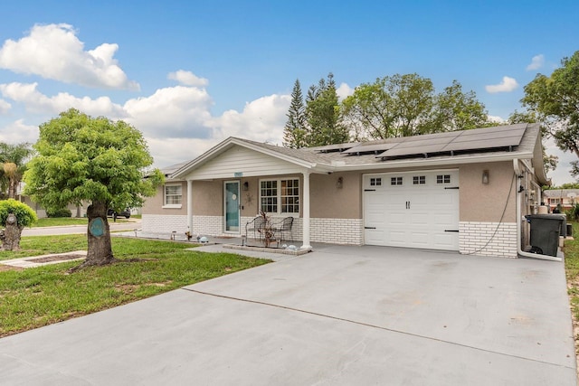 7901 Marlboro Dr, Port Richey, FL 34668 - view of front of home with a garage, roof mounted solar panels, driveway, a front yard, and covered porch