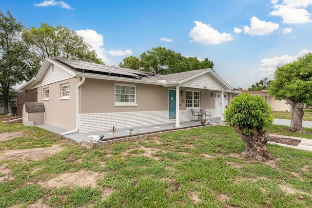 7901 Marlboro Dr, Port Richey, FL 34668 - single story home with covered porch, roof mounted solar panels, stucco siding, and brick siding
