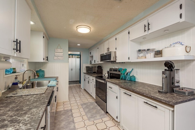 7901 Marlboro Dr, Port Richey, FL 34668 - kitchen with appliances with stainless steel finishes, open shelves, a textured ceiling, dark countertops, and white cabinetry