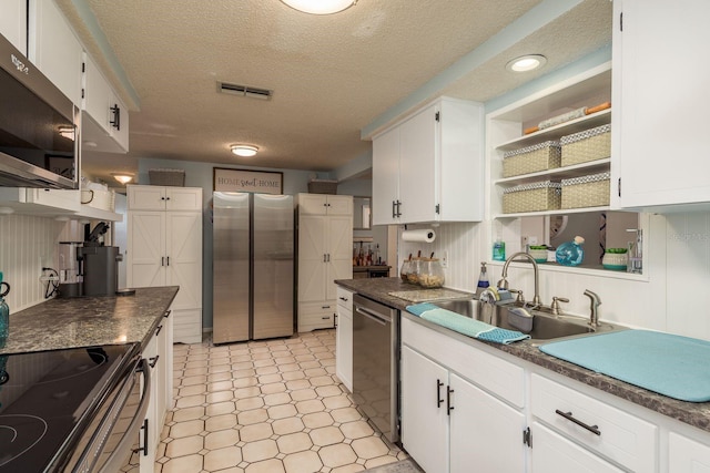7901 Marlboro Dr, Port Richey, FL 34668 - kitchen with appliances with stainless steel finishes, open shelves, white cabinetry, a textured ceiling, and dark countertops