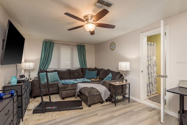 7901 Marlboro Dr, Port Richey, FL 34668 - living room featuring light wood-style floors, ceiling fan, and a textured ceiling