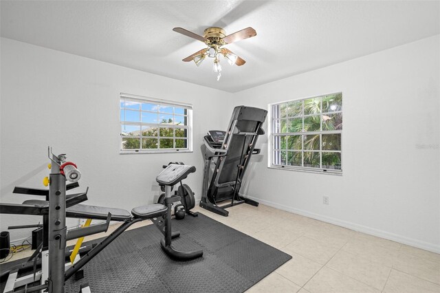 338 7th Ave N, Tierra Verde, FL 33715 - exercise room featuring healthy amount of natural light, a ceiling fan, baseboards, and light tile patterned floors