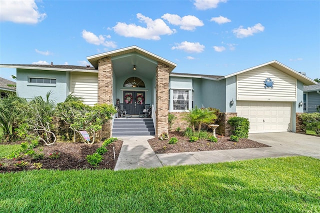 338 7th Ave N, Tierra Verde, FL 33715 - ranch-style home featuring concrete driveway, stucco siding, brick siding, an attached garage, and a front lawn