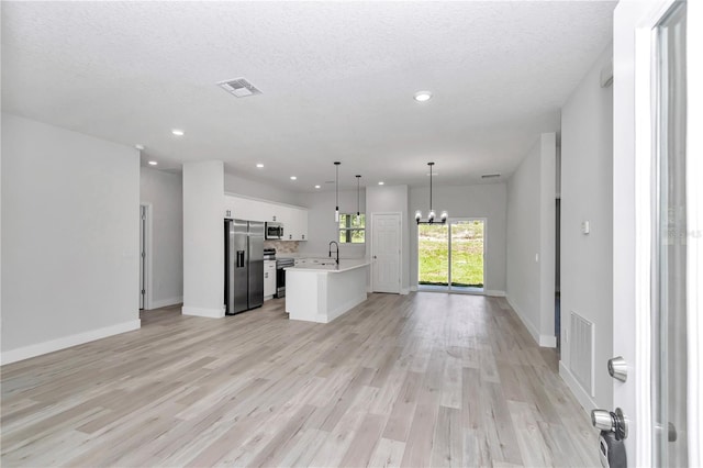 2705 W Royal Palm Dr, Citrus Springs, FL 34434 - unfurnished living room featuring a chandelier, light wood-style floors, recessed lighting, and a textured ceiling