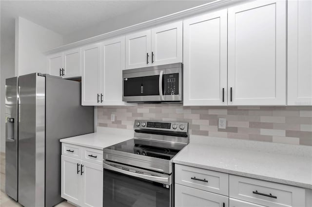 2705 W Royal Palm Dr, Citrus Springs, FL 34434 - kitchen featuring stainless steel appliances, white cabinetry, decorative backsplash, and light stone counters