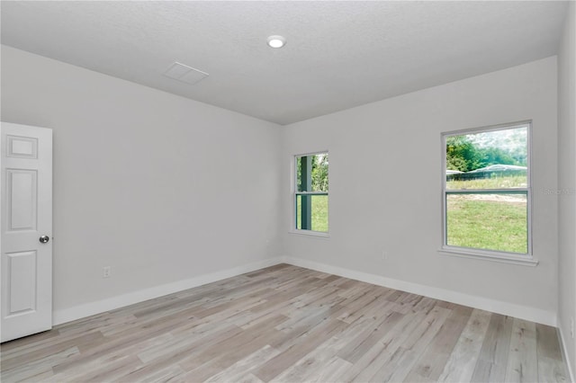2705 W Royal Palm Dr, Citrus Springs, FL 34434 - spare room featuring light wood-style flooring and a textured ceiling