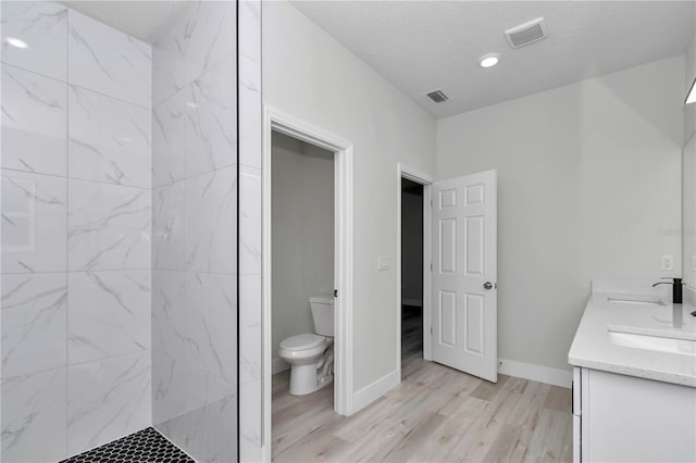 2705 W Royal Palm Dr, Citrus Springs, FL 34434 - bathroom featuring double vanity, wood finished floors, a marble finish shower, and recessed lighting