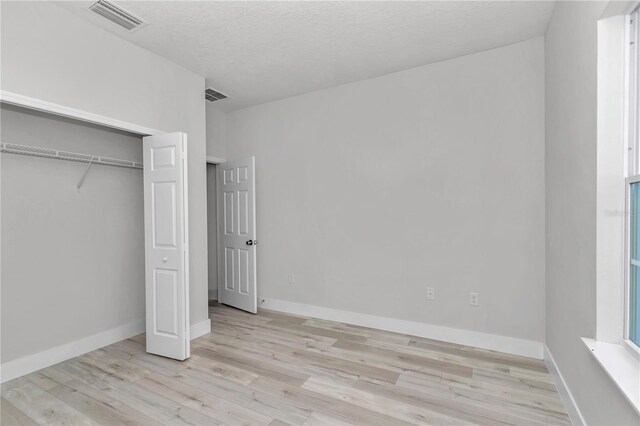 2705 W Royal Palm Dr, Citrus Springs, FL 34434 - unfurnished bedroom with light wood-style flooring and a closet