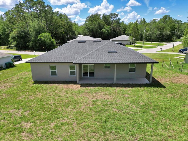 2705 W Royal Palm Dr, Citrus Springs, FL 34434 - back of property with a shingled roof, a yard, stucco siding, and a patio area