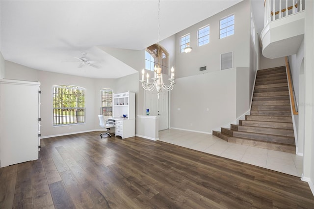 1178 Fraser Pine Blvd, Sarasota, FL 34240 - unfurnished living room with wood finished floors, ceiling fan, stairway, baseboards, and a high ceiling