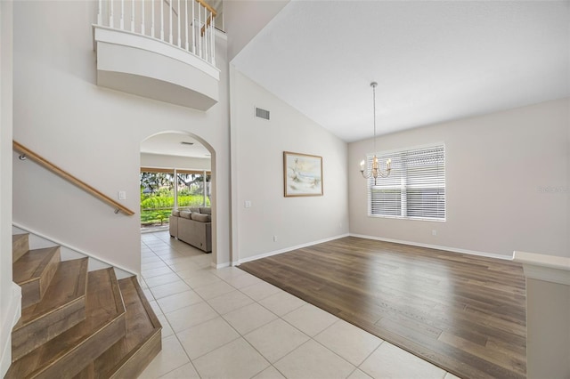 1178 Fraser Pine Blvd, Sarasota, FL 34240 - tiled entryway featuring arched walkways, high vaulted ceiling, a chandelier, stairs, and baseboards