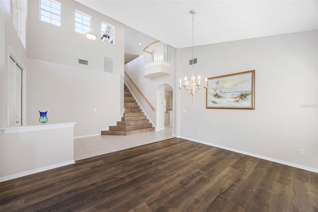 1178 Fraser Pine Blvd, Sarasota, FL 34240 - unfurnished living room featuring a high ceiling, stairs, wood finished floors, baseboards, and a chandelier
