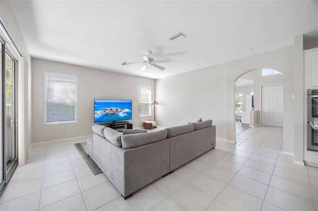 1178 Fraser Pine Blvd, Sarasota, FL 34240 - living area featuring arched walkways, light tile patterned floors, plenty of natural light, and baseboards