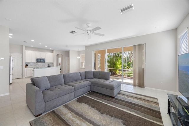 1178 Fraser Pine Blvd, Sarasota, FL 34240 - living room with light tile patterned floors, arched walkways, ceiling fan, baseboards, and recessed lighting