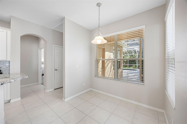 1178 Fraser Pine Blvd, Sarasota, FL 34240 - unfurnished dining area with arched walkways, baseboards, and light tile patterned floors