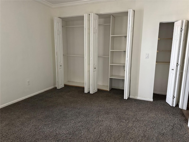 750 Island Way Unit 101, Clearwater Beach, FL 33767 - unfurnished bedroom with crown molding, dark colored carpet, baseboards, and two closets