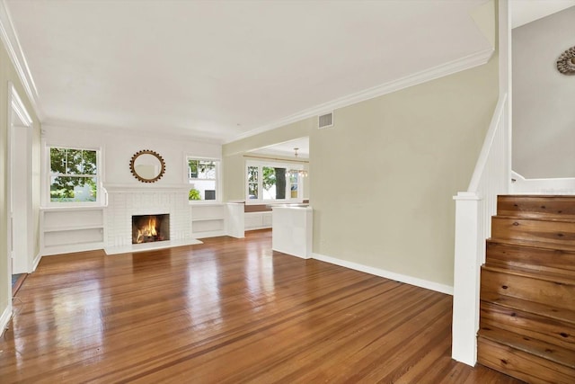 258 14th Ave NE, Saint Petersburg, FL 33701 - unfurnished living room featuring wood finished floors, a fireplace, crown molding, and stairs