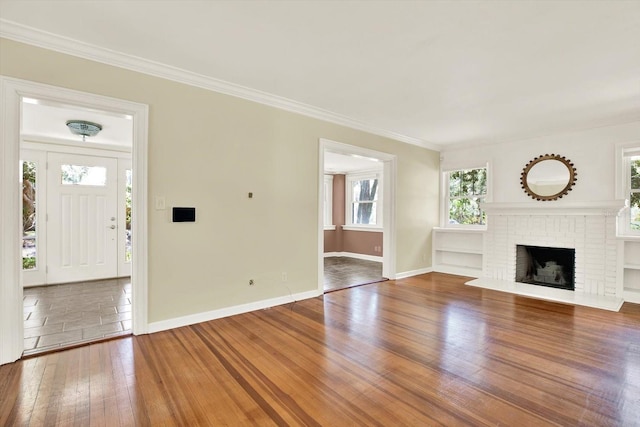 258 14th Ave NE, Saint Petersburg, FL 33701 - unfurnished living room featuring hardwood / wood-style floors, ornamental molding, and a fireplace