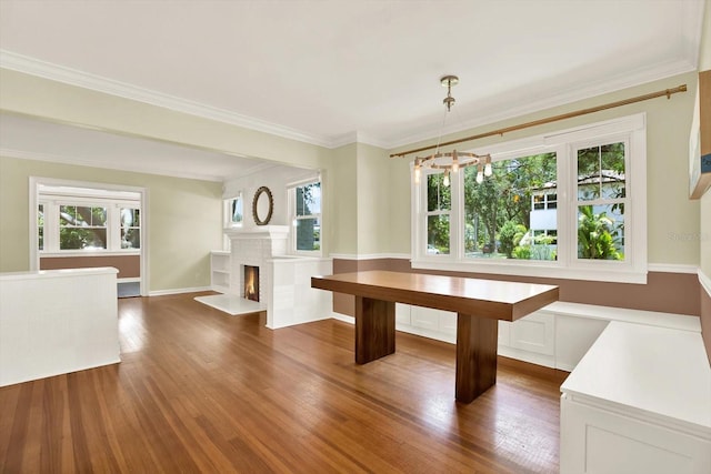 258 14th Ave NE, Saint Petersburg, FL 33701 - unfurnished dining area featuring a fireplace with flush hearth, dark wood finished floors, crown molding, and a chandelier