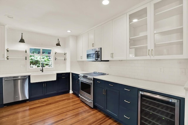 258 14th Ave NE, Saint Petersburg, FL 33701 - kitchen featuring appliances with stainless steel finishes, wine cooler, white cabinets, decorative backsplash, and light countertops