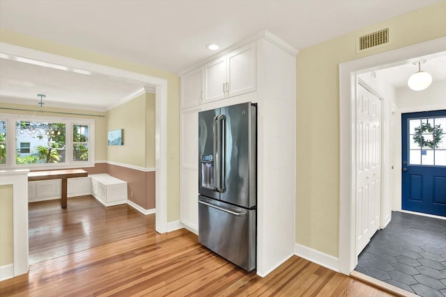 258 14th Ave NE, Saint Petersburg, FL 33701 - kitchen featuring high quality fridge, light wood finished floors, white cabinets, plenty of natural light, and crown molding