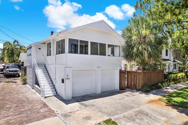 258 14th Ave NE, Saint Petersburg, FL 33701 - view of front of house with an attached garage, concrete driveway, and stairs