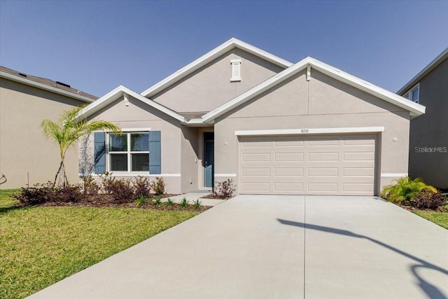 8210 Juning Cv, Wesley Chapel, FL 33545 - view of front facade with concrete driveway, a garage, a front lawn, and stucco siding