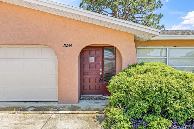 358 Suwanee Ave, Sarasota, FL 34243 - doorway to property featuring stucco siding and a garage