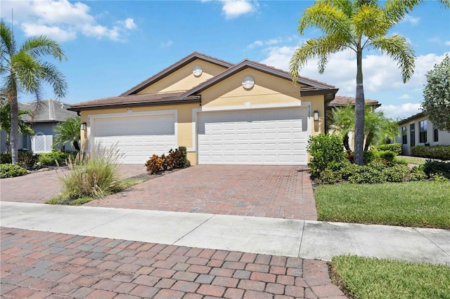 21008 Fetterbush Pl, Venice, FL 34293 - view of front of property featuring stucco siding, decorative driveway, and an attached garage