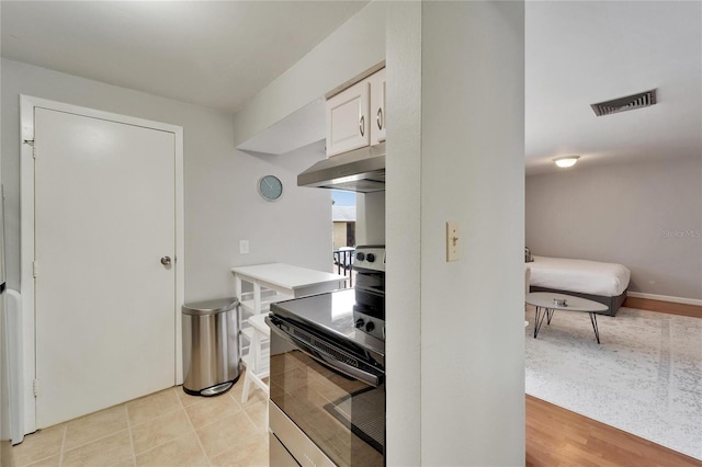 4215 E Bay Dr Unit 1801E, Clearwater, FL 33764 - kitchen with under cabinet range hood, stainless steel electric stove, white cabinetry, and light countertops