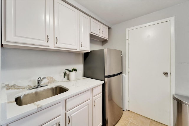 4215 E Bay Dr Unit 1801E, Clearwater, FL 33764 - kitchen featuring a sink, freestanding refrigerator, white cabinetry, and light tile patterned flooring