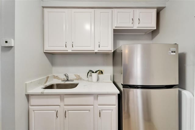 4215 E Bay Dr Unit 1801E, Clearwater, FL 33764 - kitchen featuring freestanding refrigerator, a sink, and white cabinetry