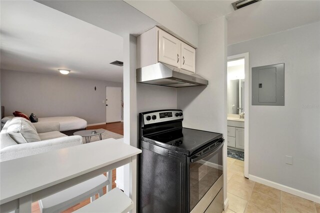 4215 E Bay Dr Unit 1801E, Clearwater, FL 33764 - kitchen featuring black electric range, under cabinet range hood, electric panel, open floor plan, and white cabinetry