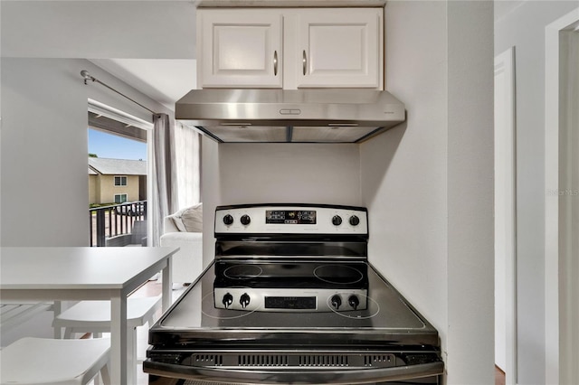 4215 E Bay Dr Unit 1801E, Clearwater, FL 33764 - kitchen featuring under cabinet range hood, stainless steel electric range, and white cabinetry