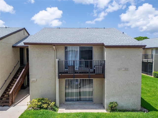 4215 E Bay Dr Unit 1801E, Clearwater, FL 33764 - back of house featuring stucco siding, a balcony, a shingled roof, and stairs