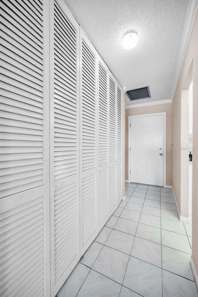 100 Bluff View Dr Unit 511C, Belleair Bluffs, FL 33770 - hall featuring a textured ceiling, ornamental molding, and light tile patterned flooring