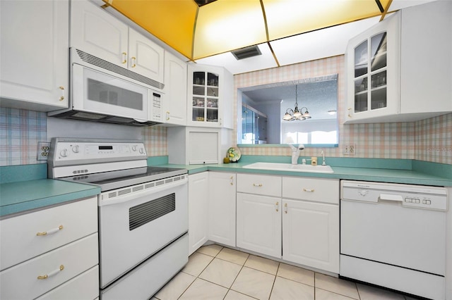 100 Bluff View Dr Unit 511C, Belleair Bluffs, FL 33770 - kitchen featuring white appliances, a chandelier, glass insert cabinets, white cabinetry, and wallpapered walls