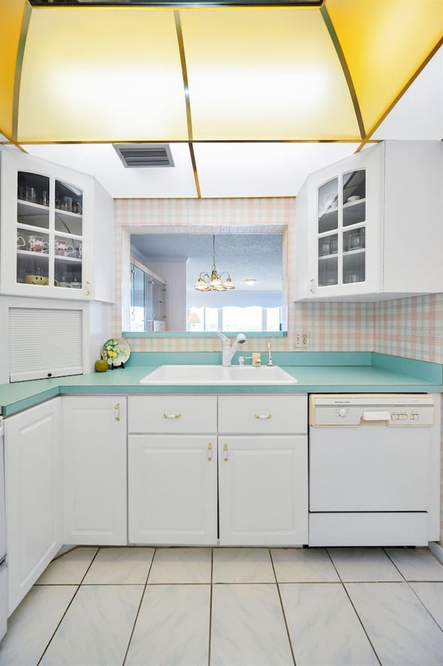 100 Bluff View Dr Unit 511C, Belleair Bluffs, FL 33770 - kitchen with white dishwasher, white cabinets, light countertops, and glass insert cabinets