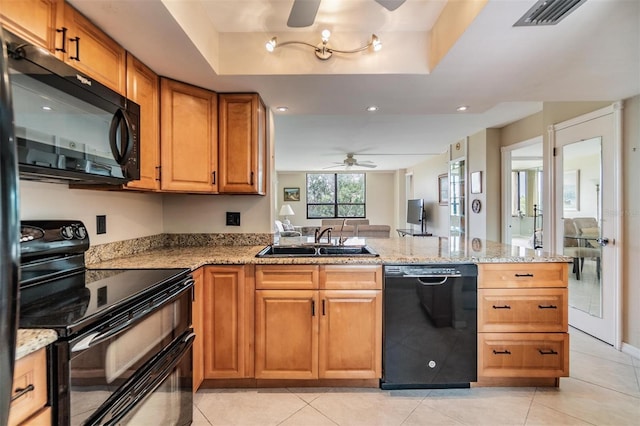 2621 Cove Cay Dr Unit 302, Clearwater, FL 33760 - kitchen featuring black appliances, ceiling fan, a peninsula, brown cabinetry, and light stone countertops