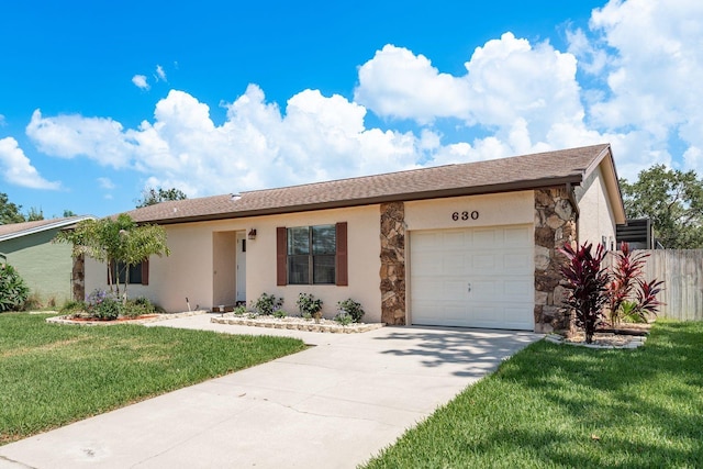 630 Kirkland Cir, Dunedin, FL 34698 - ranch-style home featuring a garage, concrete driveway, stone siding, and stucco siding