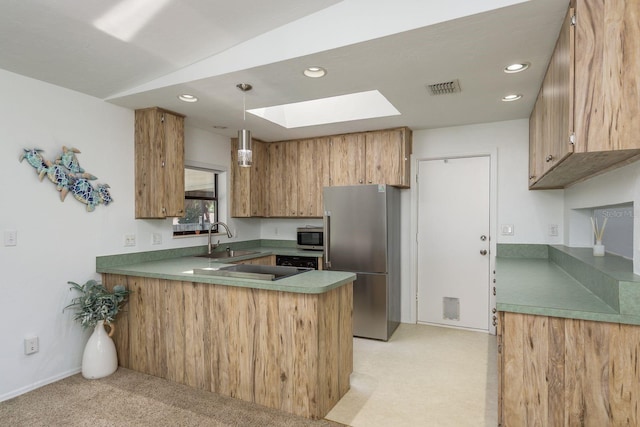 630 Kirkland Cir, Dunedin, FL 34698 - kitchen featuring stainless steel appliances, a peninsula, light colored carpet, a skylight, and recessed lighting