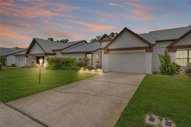 1401 Camelot Ct, Palm Harbor, FL 34684 - view of front of home with stucco siding, an attached garage, and a yard