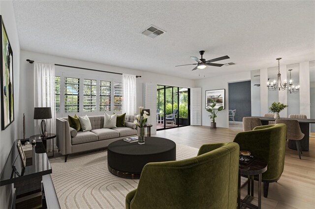 1401 Camelot Ct, Palm Harbor, FL 34684 - living area featuring a chandelier, light wood-style floors, ceiling fan, and a textured ceiling